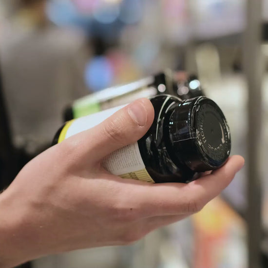 Person holding supplement bottles in a store aisle, representing Academic Supplements and Herbs Health Guide Free - ChatGPT Personal AI software tool.